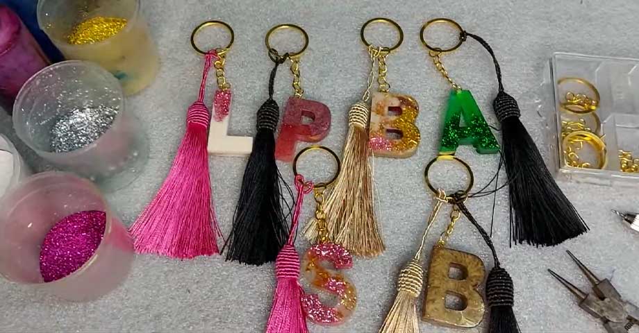 Coleção de chaveiros personalizados em resina com letras e borlas coloridas